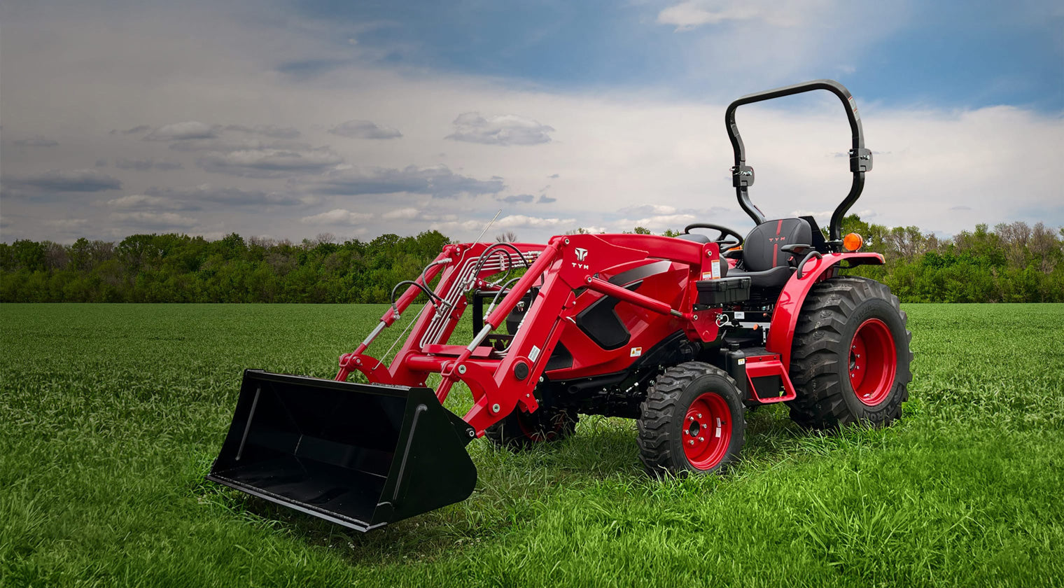 Red TYM compact tractor working in a field